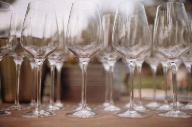 Bir sürü boş şampanya ya da şarap bardağı güneşte parlıyor. Resepsiyon ya da tatil için hazırlık, alkollü içecekler için konteynır. Restoran, yemek servisi, servis.