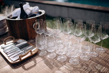 Bir sürü boş şampanya ya da şarap bardağı güneşte parlıyor. Resepsiyon ya da tatil için hazırlık, alkollü içecekler için konteynır. Restoran, yemek servisi, servis.