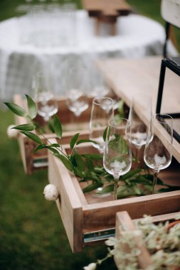 Bir sürü boş şampanya ya da şarap bardağı güneşte parlıyor. Resepsiyon ya da tatil için hazırlık, alkollü içecekler için konteynır. Restoran, yemek servisi, servis.