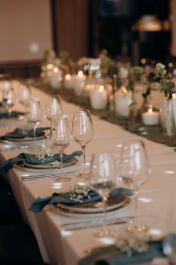 Masa alkol, peçete ve sofra takımı için zarif bardaklarla dolu. Yemek servisi, yemek servisi, restoran, resmi yemek.