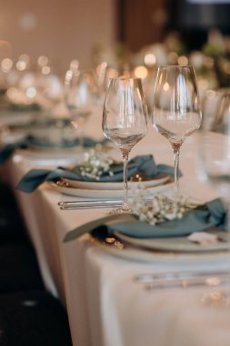 Masa alkol, peçete ve sofra takımı için zarif bardaklarla dolu. Yemek servisi, yemek servisi, restoran, resmi yemek.