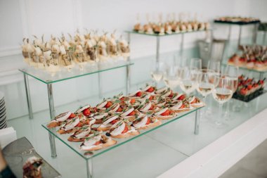 Yemek, güzel dekore edilmiş bir ziyafet masası peynirli, jambonlu, jambonlu ve meyveli çeşitli aperatifler. Şirket, Noel, doğum günü ya da düğün kutlamalarında. Büfe masası. Resepsiyonda büfe var. Ziyafet servisi..