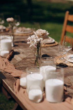 Bir sürü küçük pembe ve beyaz çiçek aranjmanı gül, östoma ve cam vazolarda çeşitli çiçekler. Düğün ziyafeti alanındaki şenlik masasında çiçekler ve yeşillik kompozisyonları, mumlar yerleştirilir..