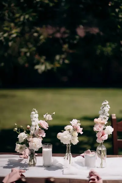 Eustoma 명확한 유리병에 분홍색과 연회장 테이블에 녹지의 양초가 배치됩니다 스톡 사진