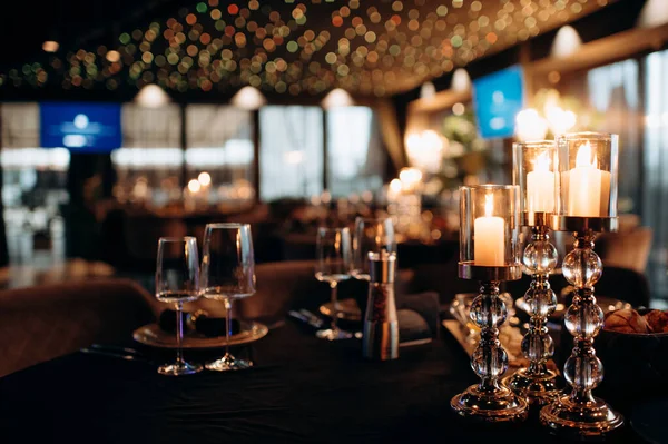 결혼식 지역의 테이블에서 양초는 녹지의 구성의 촛대에 배치됩니다 로열티 프리 스톡 사진
