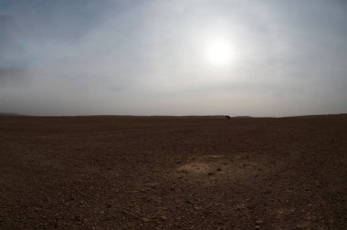 Çölde bir öğle güneşi geniş açılı bulutlar ve şeritler arasında.