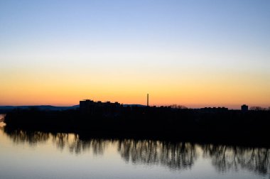 Tuna Nehri 'nden Sturovo şehrine ağaçların yansımasıyla gönderilen bir güneş.