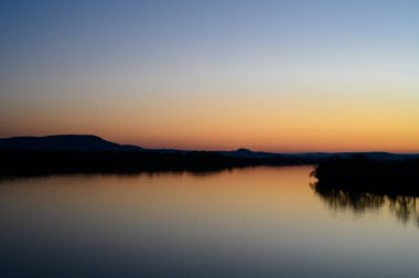 Tuna nehrinin iki kıyısında gün batımı yansıması