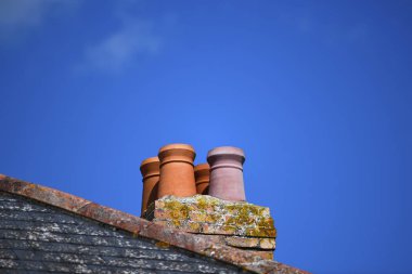 kopya alanı odak konuda reklam için ideal için çatı açık mavi gökyüzü arka plan üzerinde dört pişmiş toprak baca seti 