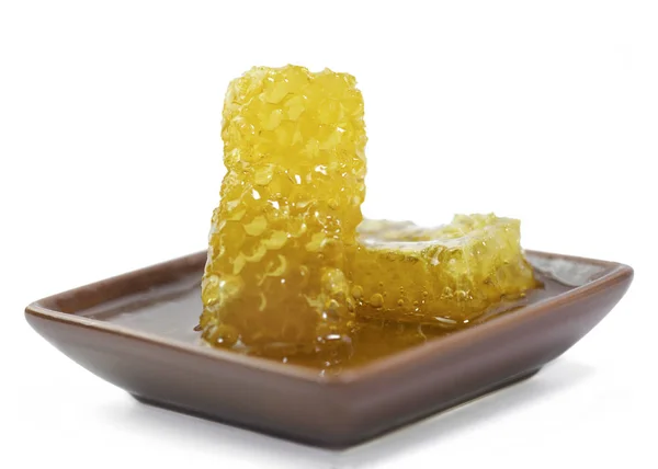 つの小皿に注いで蜂蜜 被写体に焦点を当てると白い背景で隔離の黄金有機ハニカム — ストック写真