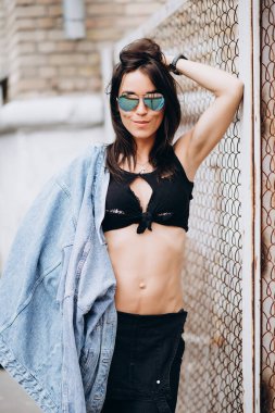 Parkta siyah elbiseli ve gözlüklü güzel bir atletik kız. Sağlıklı bir yaşam tarzı. Yumuşak seçici odak.