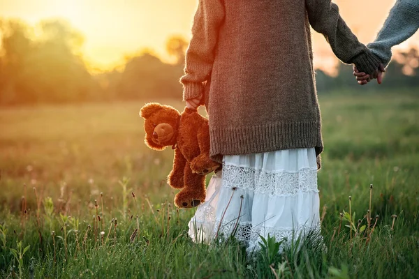 Bebé Niña Sostiene Osito Peluche Mano Amanecer Hierba —  Fotos de Stock