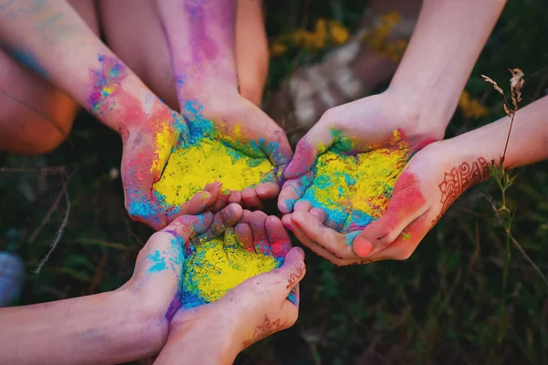 Multi-colored coloring powder in the hands at the Holly Festival.