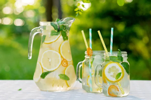 Limonata Tazeleyici Bir Içecek Limonlu Kavanozlar Bahçe Masasında Taze Nane — Stok fotoğraf