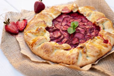 Taze pişmiş ev yapımı galet ya da açık çilekli turta ve taze nane yaprağı, yaz yemeği. Yumuşak seçici odak.