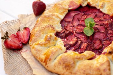 Taze pişmiş ev yapımı galet ya da açık çilekli turta ve taze nane yaprağı, yaz yemeği. Yumuşak seçici odak.