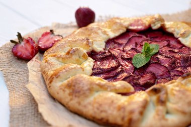 Taze pişmiş ev yapımı galet ya da açık çilekli turta ve taze nane yaprağı, yaz yemeği. Yumuşak seçici odak.