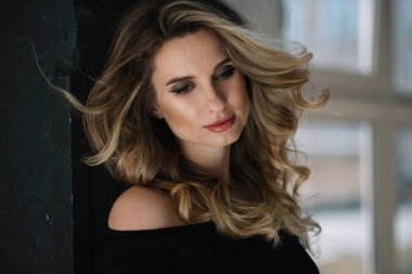 Güzel romantik bir kızın yakın plan portresi seksi dolgun dudaklı ve stüdyoda kıvrımları gelişen. Yumuşak seçici odak.