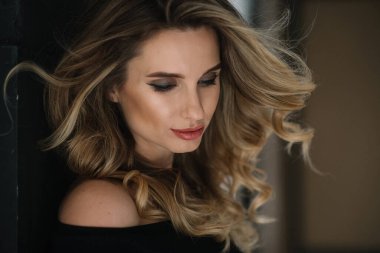 Güzel romantik bir kızın yakın plan portresi seksi dolgun dudaklı ve stüdyoda kıvrımları gelişen. Yumuşak seçici odak.