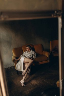 Zarif, zarif, bej renkli, deri ceketli ve dumanlı göz makyajlı bir sarışının şık portresi stüdyoda. Bahar - sonbahar moda konsepti. Yumuşak seçici odak.