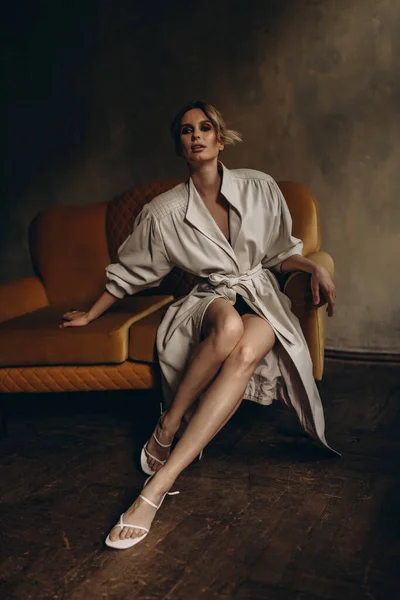 Zarif, zarif, bej renkli, deri ceketli ve dumanlı göz makyajlı bir sarışının şık portresi stüdyoda. Bahar - sonbahar moda konsepti. Yumuşak seçici odak.