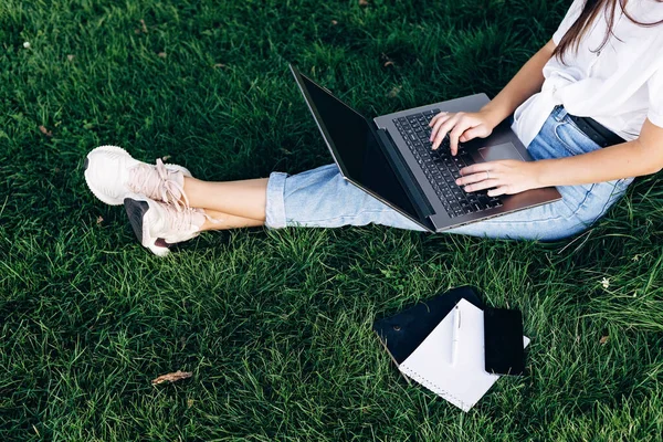 坐在草地上 在网上冲浪或准备考试的女学生 教育和远程工作概念 软性选择性重点 — 图库照片