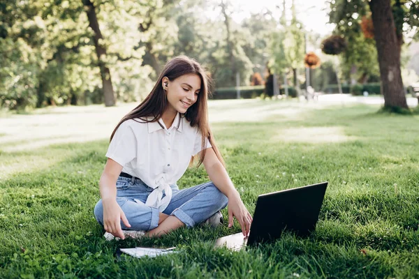 Studentka Laptopem Zewnątrz Uśmiechnięta Kobieta Siedząca Trawie Komputerem Surfująca Internecie — Zdjęcie stockowe