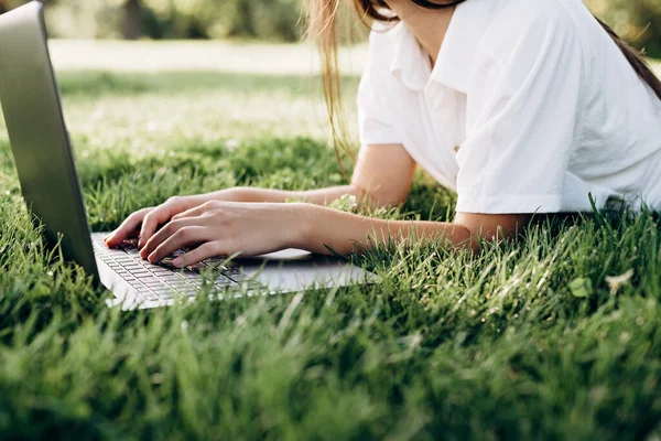 在户外带笔记本电脑的女学生 女人靠电脑躺在草地上 上网或准备考试 教育和远程工作概念 软性选择性重点 — 图库照片