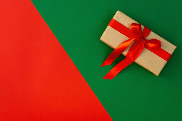 Vánoční Minimální Kompozice Dárková Skříňka Saténovou Mašlí Dekorace Červenozeleném Pozadí — Stock fotografie