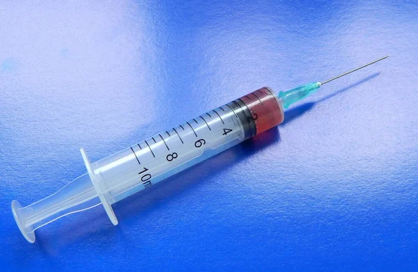Syringe with medicine on a blue background close up