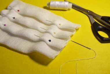 Gazlı bez yüz maskesi, makas, gazlı bez, iğne ve iplik dikme işlemi.