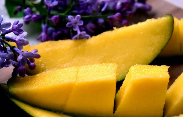 Olgun bir mango meyvesiyle leylak arkaplanını keserek..