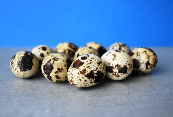 Mavi-gri arka planda on bıldırcın yumurtası.