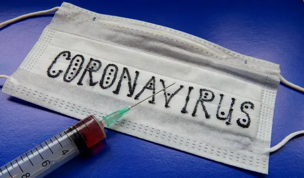 Koruyucu, tıbbi maske, ilaçlı şırınga. Koronavirüse karşı aşı kavramı.