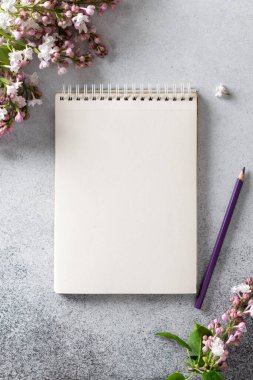 defter ve kalem, leylak dalının yanında.