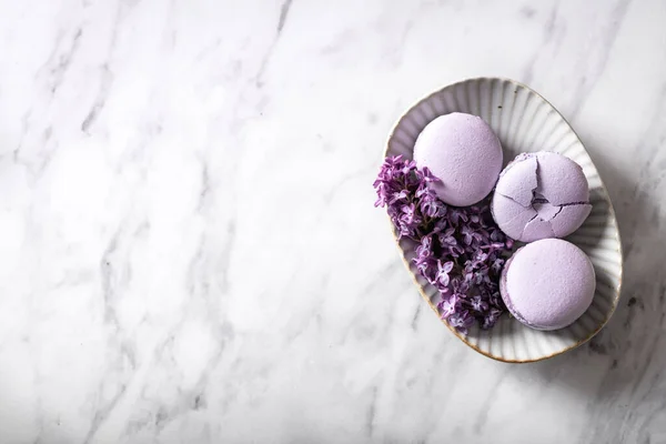 Purple macaroons with lilac flowers — Stock Photo, Image