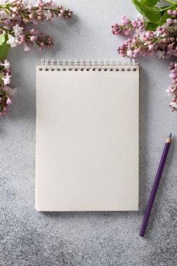 defter ve kalem, leylak dalının yanında.