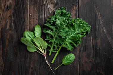 Kara ahşap arka planda lahana ve ıspanak.