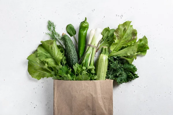 Fresh vegetables and greens in a paper bag, healthy food concept