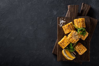 Koyu arkaplanda ızgara mısır, üst görünüm, kopyalama alanı