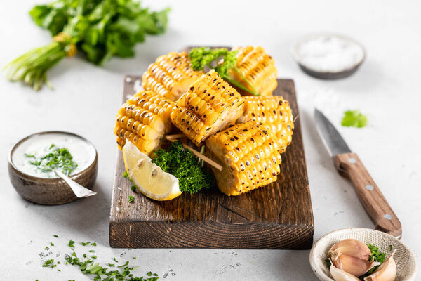 corn cobs grilled on a kitchen board on a white background
