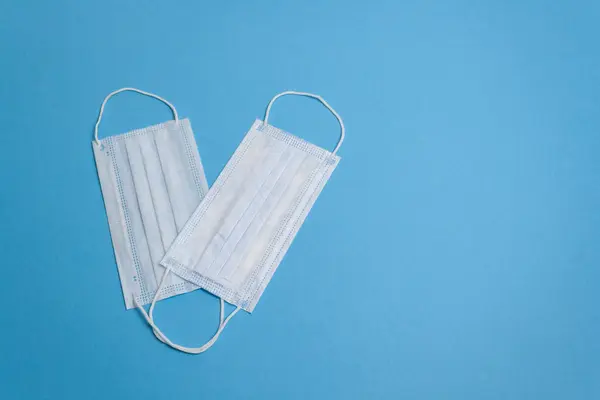 Две белые медицинские маски на синем фоне изолировать — стоковое фото