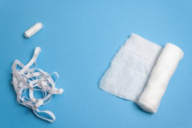 Gazlı bez, iplik, mavi arka planda kauçuk.