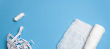 Gazlı bez, iplik, mavi arka planda kauçuk.