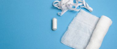 Gazlı bez, iplik, mavi arka planda kauçuk.