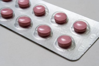 Pembe yuvarlak haplar, bir paket gri arka plan.