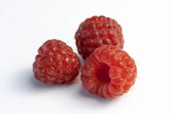 Trois framboises mûres isolées sur fond blanc — Photo