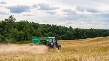 Mavi traktör tarlada çalışıyor.