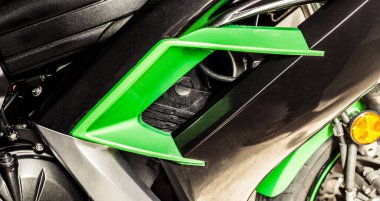 Yeşil hava girişi, motosiklet motoru silindiri ve ön tekerleğin bir kısmı yakın plan. Bir spor motosikleti parçası, yan görüş. Hava soğutma ve fren sistemi. Web sitesi için pankart