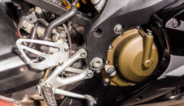 Motorsikletin altın rengi motoru. Gümüş renkli siyah bisiklet, en üst taraf manzaralı. Silindirli motorsiklet içten yanmalı motoru, motor hava soğutma sistemi, karbüratör, yakıt sistemi, tekerlekler, basamaklar